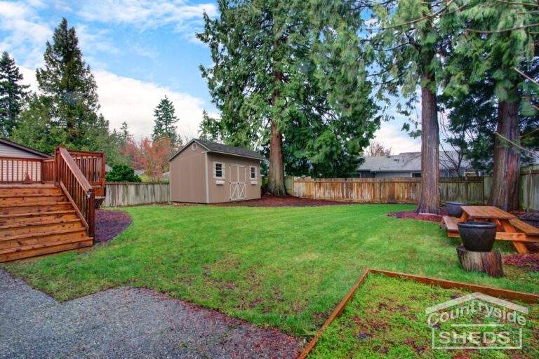 View of a back yard with green grass and small shed